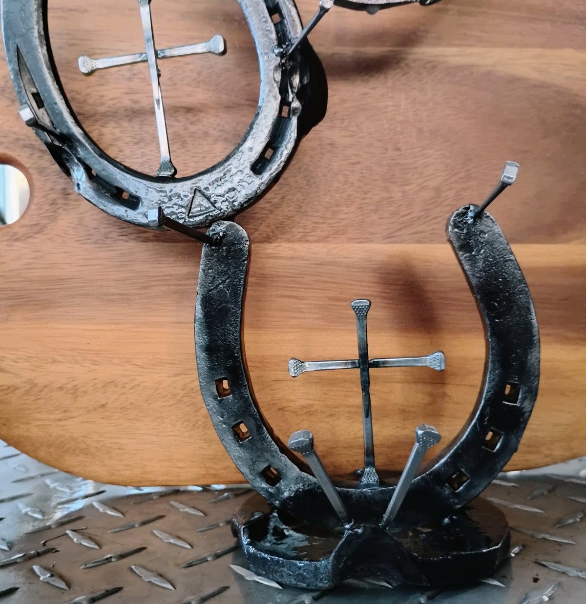 Handmade horseshoe jewelry holder standing upright — crosses welded to center of the horseshoe, rustic Western Christian décor handcrafted in Montana
