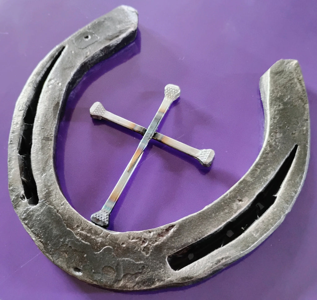 Close-up of a handmade Western cross made from polished horseshoe nails centered inside a rugged steel horseshoe halo, purple background — handcrafted Christian wall art from Christian Wall Crosses